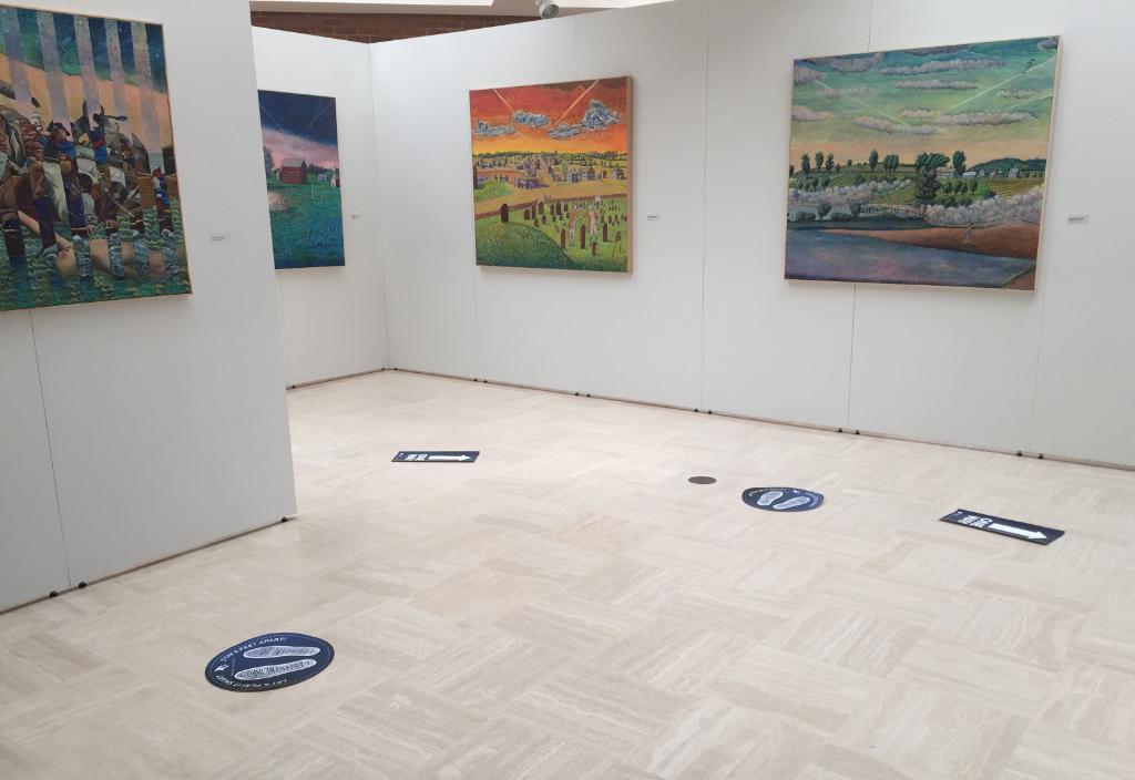 inside view of the UAG exhibit with 4 large acrylic paintings visible